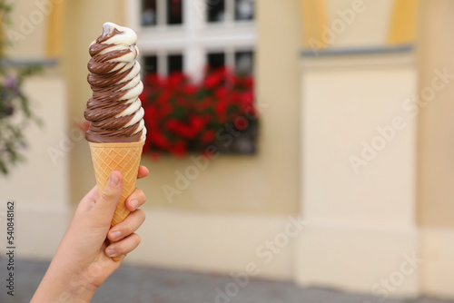 Woman holding delicious ice cream outdoors  closeup. Space for text