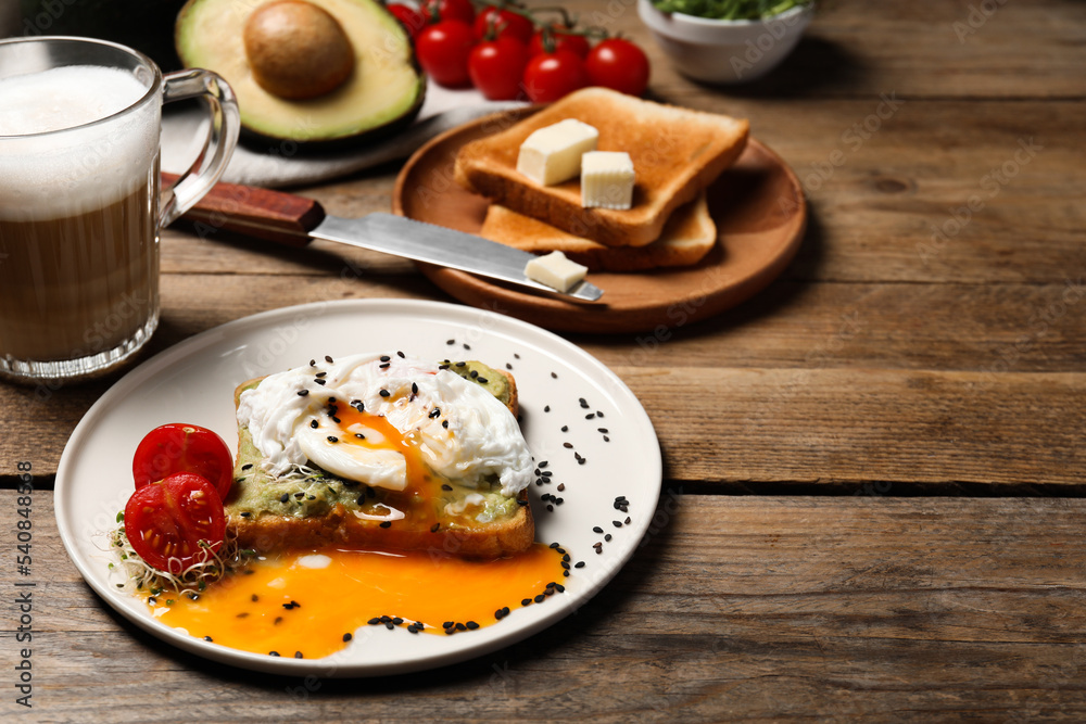 Delicious toast with poached egg and avocado served on wooden table Delicious toast with poached egg and avocado served on wooden table