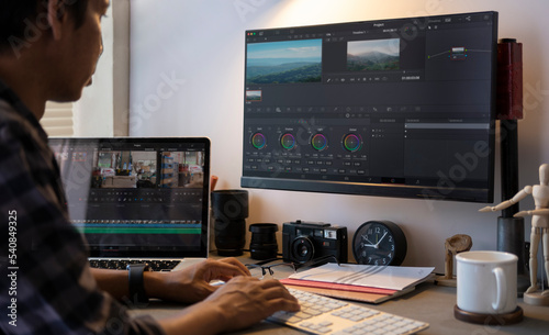 Cropped shot of male video editor working on professional computer with video editing and color correction.