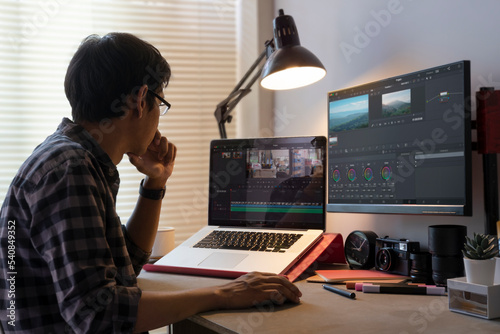 Male freelancer editing video on computer with professional program in home office. photo
