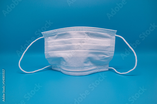 white medical mask for corona times with free space and    blue background, isolated