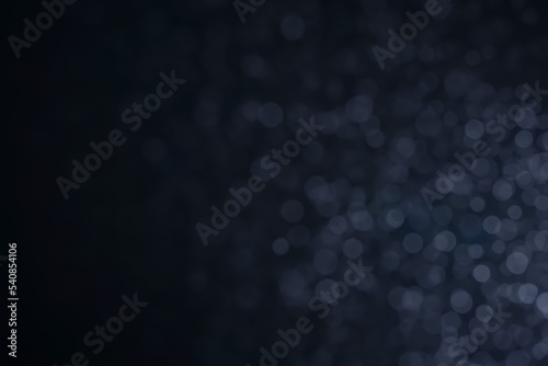 A dark blue background bokeh image for used to decorate background.