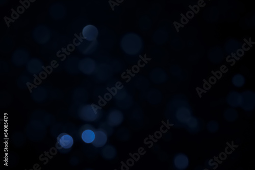 A dark blue background bokeh image for used to decorate background.