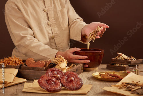 Chinese traditional medicine with a doctor for advertising and a natural herb on a brown wooden table background.