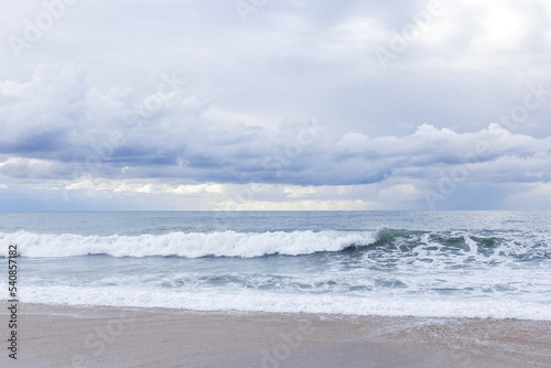 Big sea waves crashing on sandy beach