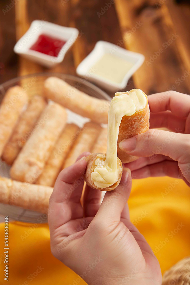 Delicious melted cheese stick, hand-held photo of typical Colombian food, exquisite bread