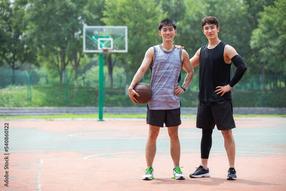 Happy young men playing basketball outdoors Happy young men playing basketball outdoors