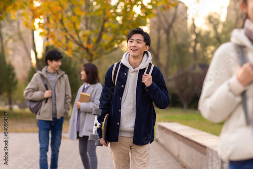 Happy college students walking on campus