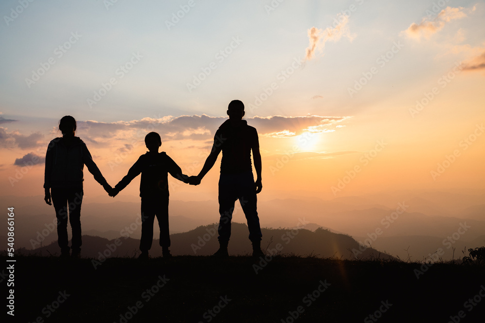 Happy family. silhouette mother father and child on the mountain  nature on sunset.
