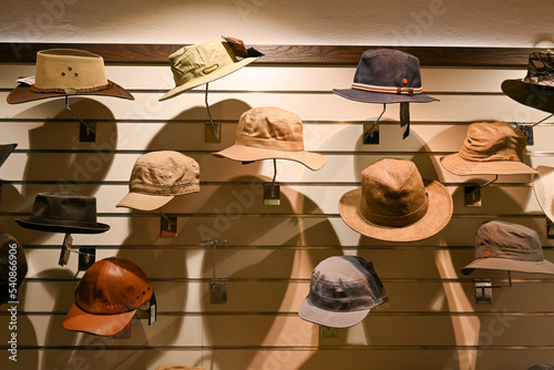 Sommerhüte und Hüte hängend an der Wand und warten auf den Verkauf in eim Hutgeschäft in Bozen, Italien photo