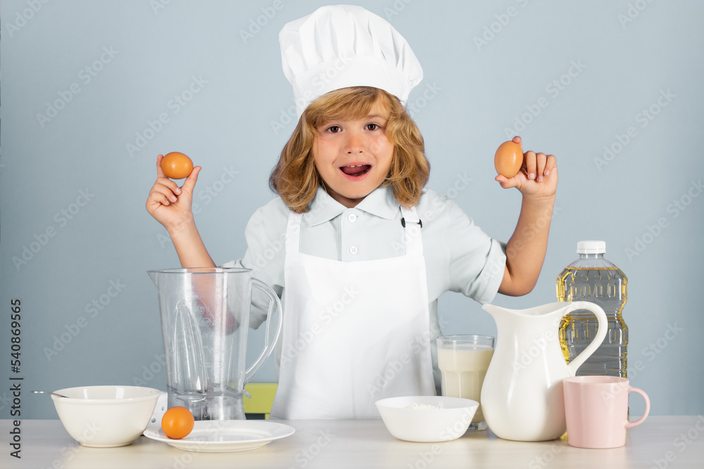 Portrait of chef child in cook hat hold eggs. Cooking at home, kid boy preparing food from vegetable and fruits. Healthy eating. Portrait of chef child in cook hat hold eggs. Cooking at home, kid boy preparing food from vegetable and fruits. Healthy eating.