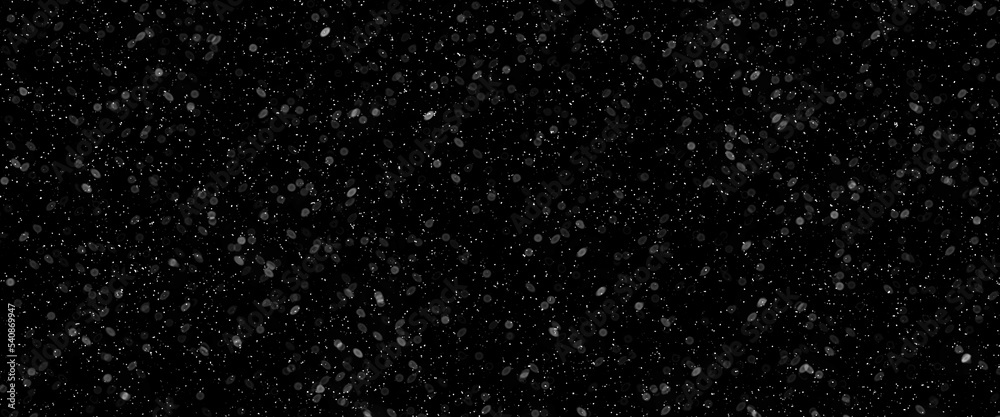 Snowfall bokeh on black background. Many snowflakes in flying in the air. Winte night snowfall and blizzard of snow at. Blur bokeh light effect creative background