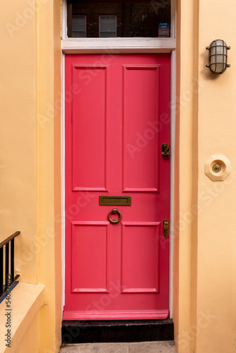 Red front door, with mail slot and a door bell