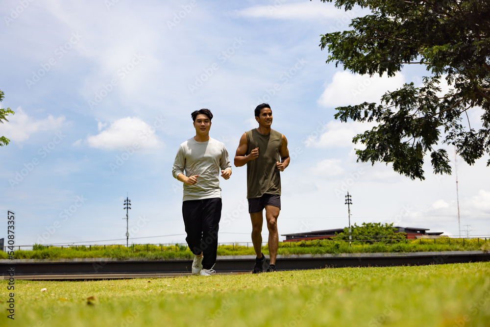 Asian young man jogging together in green park. Concept for healthy lifestyle and oudoor life. Asian young man jogging together in green park. Concept for healthy lifestyle and oudoor life.