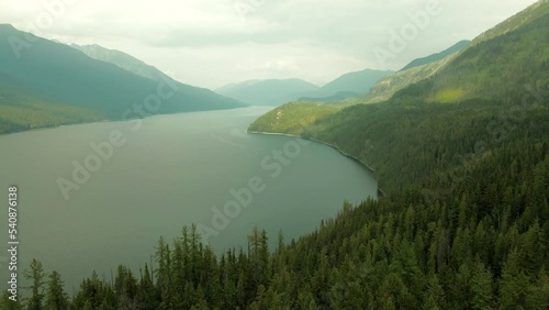 Arcing shot revealing the stunning Slocan Lake over the dense forest photo