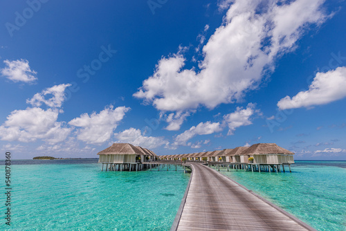 Amazing beach landscape. Beautiful Maldives lagoon bay seascape view. Horizon sunny sea sky clouds, over water villa pier pathway. Tranquil island lagoon, tourism travel background. Exotic vacation © icemanphotos
