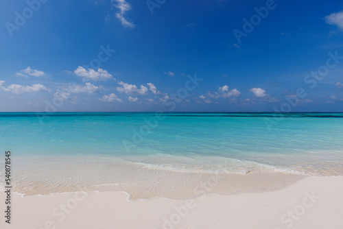 Closeup of sand on beach and blue summer sky. Panoramic beach landscape. Empty tropical beach and seascape. Peaceful shore, waves surf calmness, tranquil relaxing sunlight, summer mood