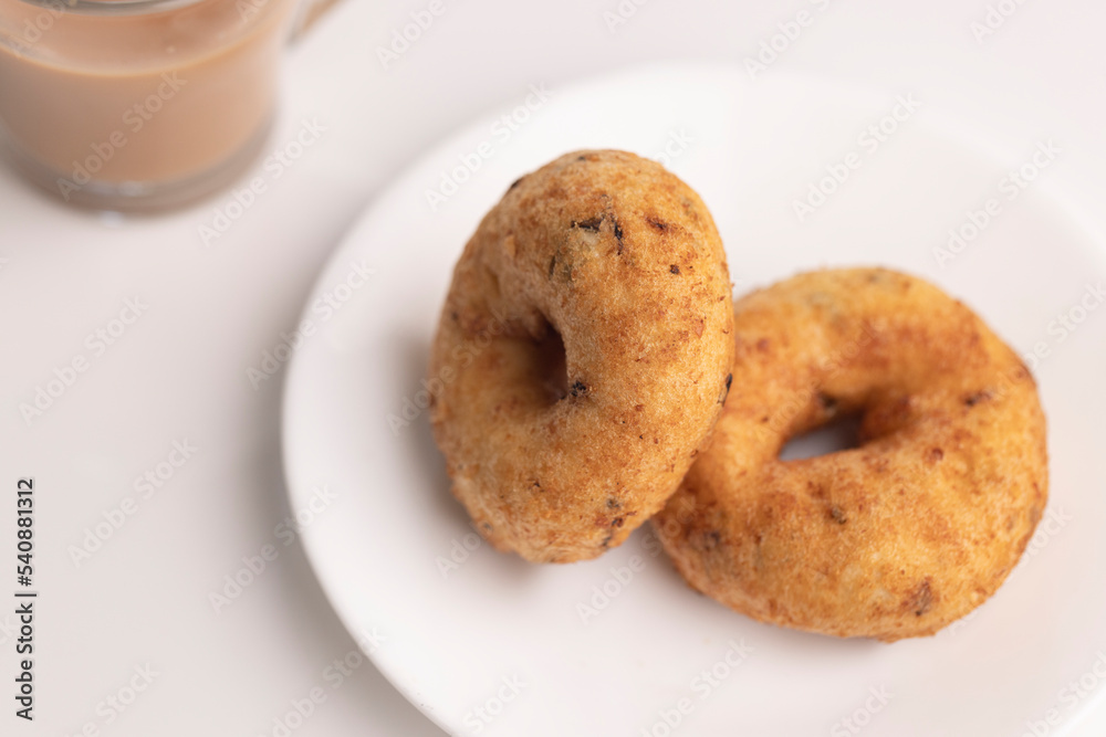 plate of methu vadai with cup of tea on table. plate of methu vadai with cup of tea on table.