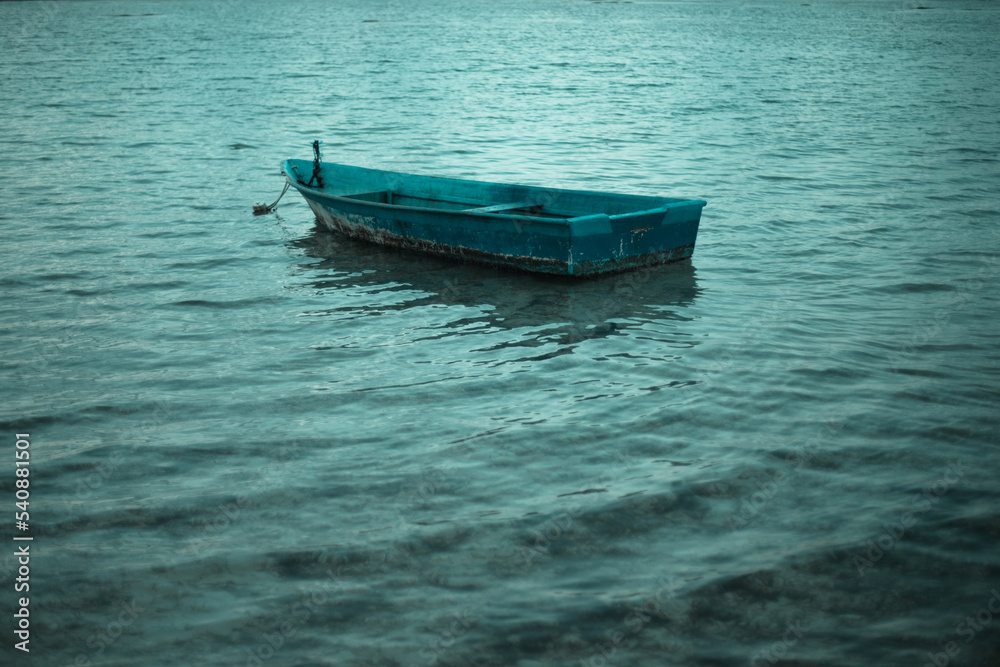 Old alone boat floating in the calm water
