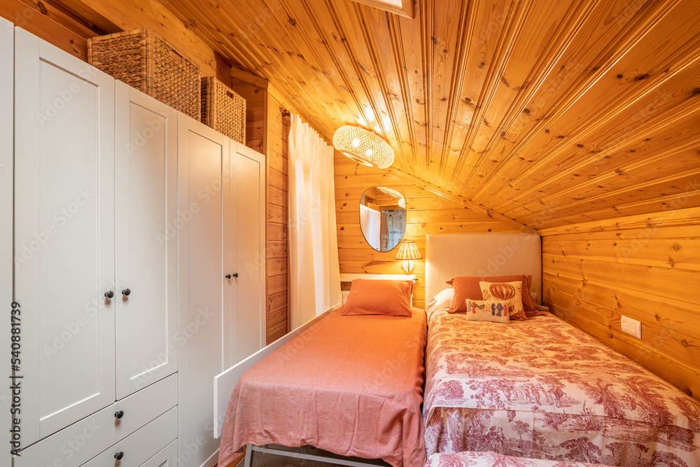 Small bedroom with two beds and white wardrobe in a modern cottage with ...
