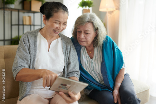 Fotografia Senior Woman Showing Book to Friend
