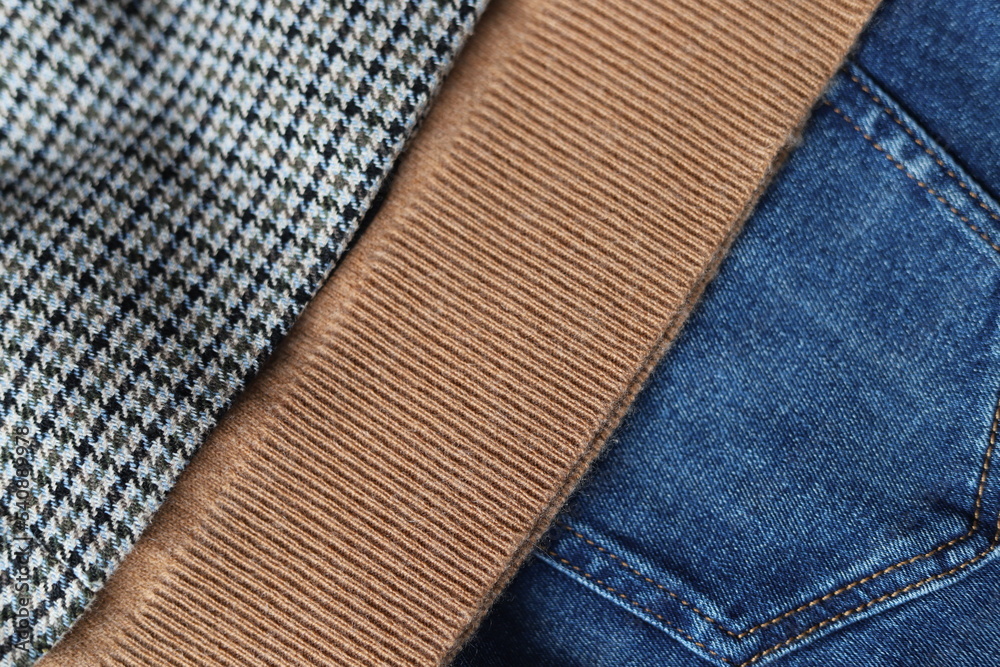 Woolen checked blazer, cashmere sweater, blue jeans. Close up. Woolen checked blazer, cashmere sweater, blue jeans. Close up.