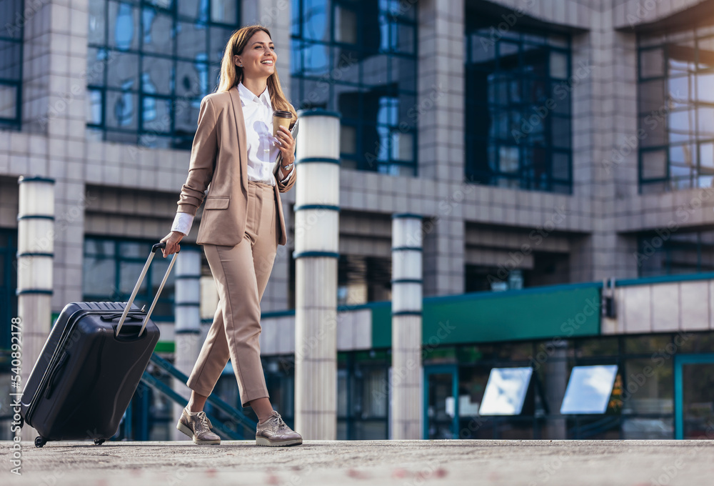 Business woman travel to airport hotel or office. Portrait of young professional walking in city street with suitcase bag Stock Adobe Stock