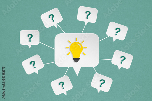 bright lightbulb and question mark on white speech bubble paper cut on grunge green background