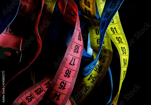 colorful measuring tapes on a black background