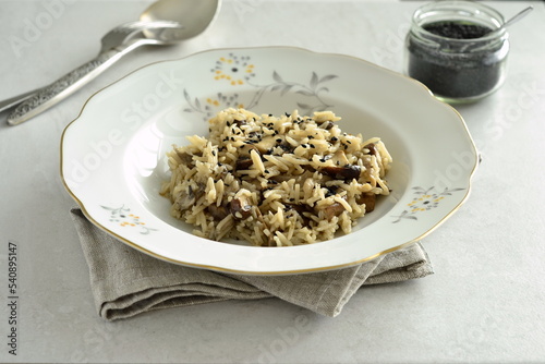 Basmati rice with brown mushrooms and sesame seeds on a gray stone background