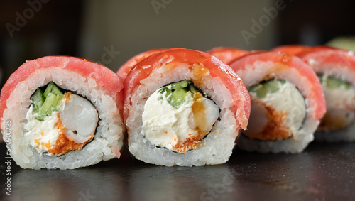 Sushi set, Japanese food, sushi roll with tuna and tiger shrimp on black stone background.