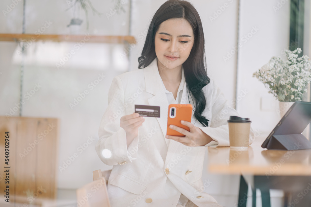 Happy asian Business woman pay online using mobile phone at the office. Happy asian Business woman pay online using mobile phone at the office.