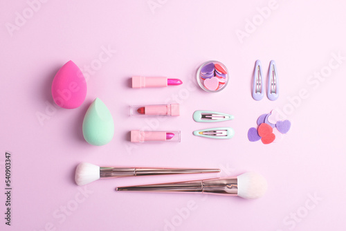 Girls makeup flat lay with various cosmetic products isolated on pink background. Knolling composition, top view.