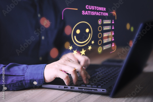 Businessman hand using computer laptop with popup five star icon for feedback review satisfaction service, testimonial. Customer service experience and business satisfaction survey.