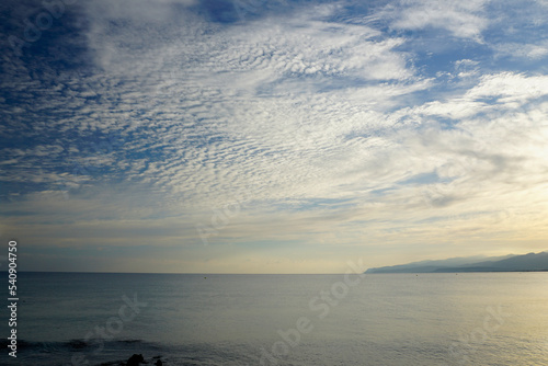 Sunrise over the mountains on the shores of the Aegean Sea. October morning. The magic of nature. The island of Crete. Bright light and haze perspective.