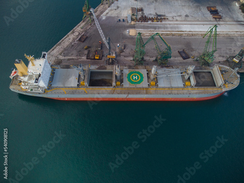 Aerial view of big cargo ship bulk carrier is loaded with coal in port