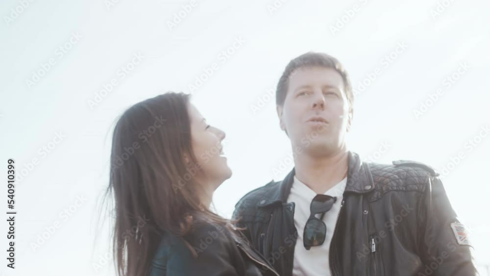 A man and a woman in love laugh, hug and flirt with each other on a walk on the street in the summer A man and a woman in love laugh, hug and flirt with each other on a walk on the street in the summer