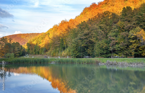 Autumn in the mountains near the lake. Beautiful reflection in the water.