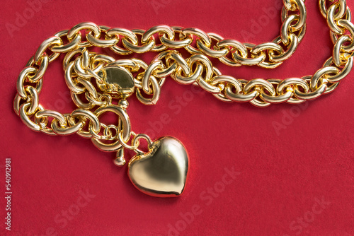 Gold necklace on red background