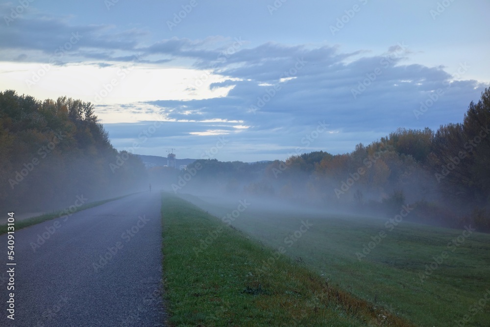 early gloomy morning on bicycle path to the town in autumn