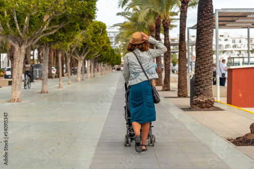 A mother with her daughter in the palm tree park in San Antonio Abad in the port, Ibiza Island. Balearic