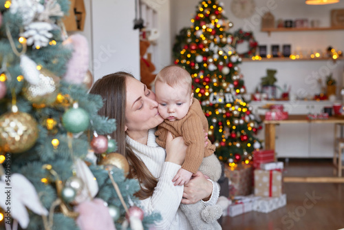 Mother with baby on background of Christmas tree. Christmas family.