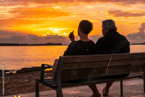 An elderly couple on the promenade at sunset in San Antonio Abad, Ibiza Island