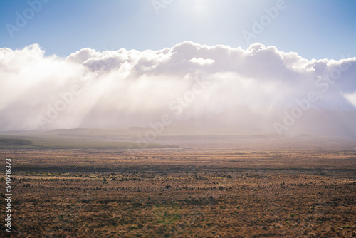 Sun shines over low clouds above vast and empty land along Volcanic Loop Hwy and Desert Road. Central Plateau, New Zealand