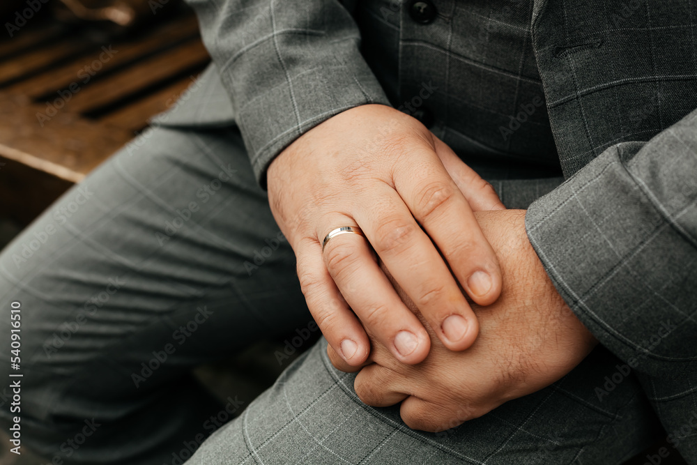 Hands of a man with a gold ring in a suit Hands of a man with a gold ring in a suit