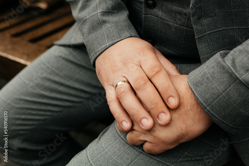 Hands of a man with a gold ring in a suit