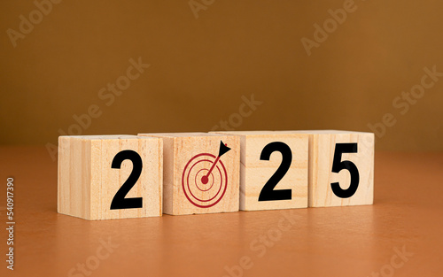 Business planning in 2025. Wooden cubes with the letters 2025 on a table with a brown background