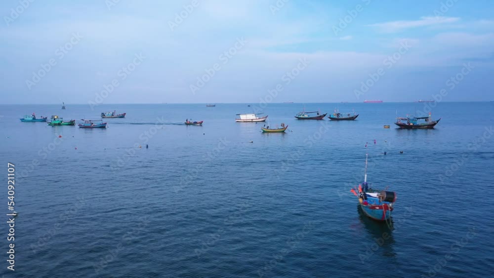 Fishing boats anchored in front of the marina in Vung Tau iin early morning light. A long right to left aerial tracking shot showing many different types of boats. Fishing boats anchored in front of the marina in Vung Tau iin early morning light. A long right to left aerial tracking shot showing many different types of boats.