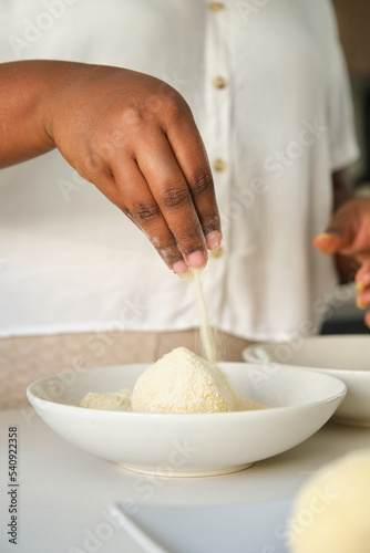 Close up of cuban woman hands breading mashed potatoes balls to prepare cuban style stuffed potatoes.