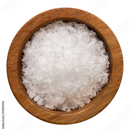 Sea salt flakes in a wood bowl isolated from above.